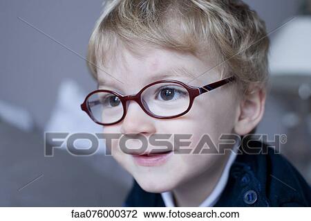 Stock Image - Little boy wearing glasses, portrait. Fotosearch