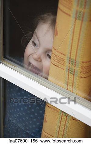 Stock Photograph - Little girl looking through window. Fotosearch
