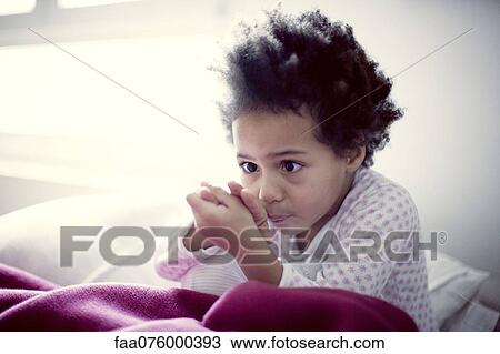 Little girl sitting on bed, studying her hand View Large Photo Image Stock Image - Little girl sitting on bed, studying her hand. Fotosearch