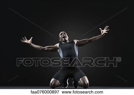Stock Photo - Male athlete kneeling and shouting with despair. Fotosearch