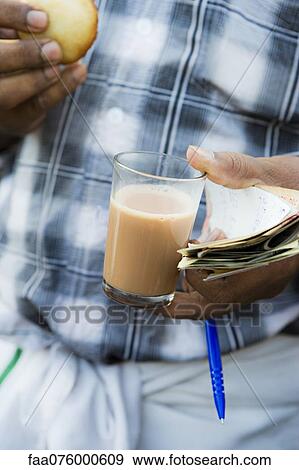 Man holding glass of chai tea, mid section View Large Photo Image Stock Photo - Man holding glass of chai tea, mid section. Fotosearch