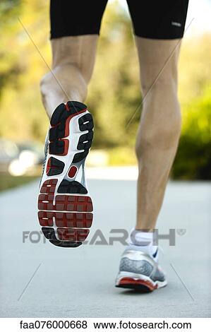 Stock Photo - Man jogging, low section, rear view. Fotosearch