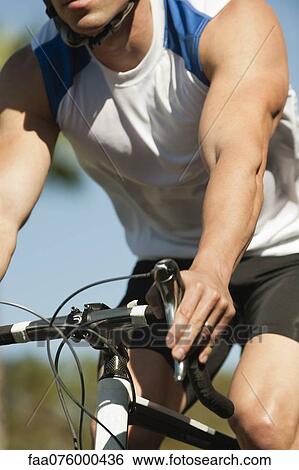 Stock Photograph - Man riding bicycle, mid section. Fotosearch