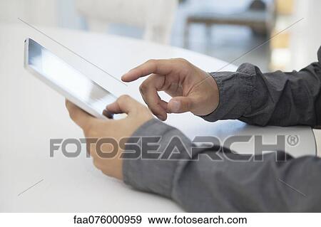 Stock Photo - Man using digital tablet, cropped. Fotosearch