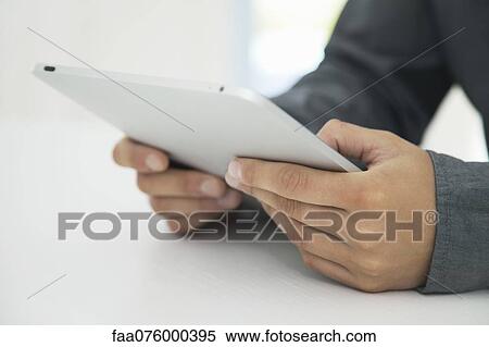 Stock Photography - Man using digital tablet, cropped. Fotosearch