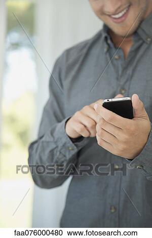 Man using smartphone, mid section View Large Photo Image Stock Image - Man using smartphone, mid section. Fotosearch