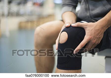 Stock Image - Man wearing knee brace, cropped. Fotosearch