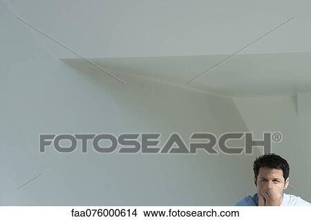 Man with hands clasped in front of mouth, worried expression on face View Large Photo Image Picture - Man with hands clasped in front of mouth, worried expression on face. Fotosearch