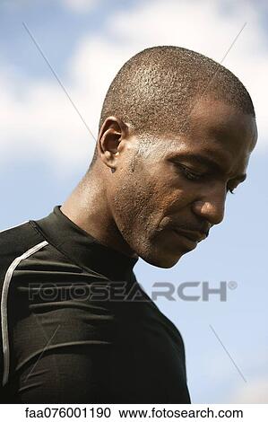 Stock Image - Man with head down in thought, portrait. Fotosearch