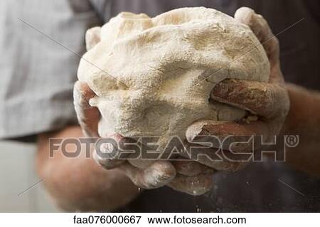 Stock Photo - Man's hands holding fresh bread dough. Fotosearch