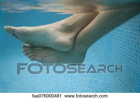 Man's legs in water, underwater view View Large Photo Image Stock Image - Man's legs in water, underwater view. Fotosearch