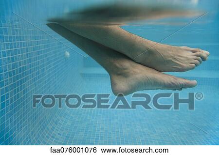 Stock Photograph - Man's legs in water, underwater view. Fotosearch