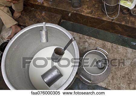Stock Photography - Milk in bucket with ladles, overhead view. Fotosearch