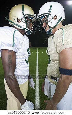 Stock Image - Opposing football players facing off. Fotosearch