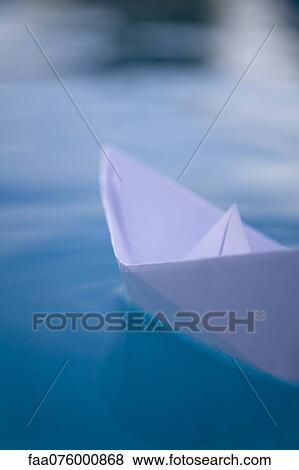 Stock Photo - Paper boat floating on water. Fotosearch