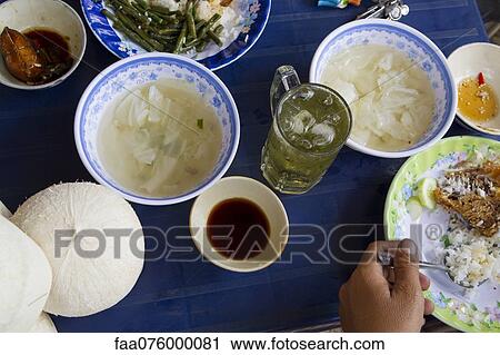Stock Image - Person eating street food. Fotosearch