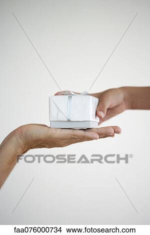 Person giving a gift, cropped View Large Photo Image Picture - Person giving a gift, cropped. Fotosearch