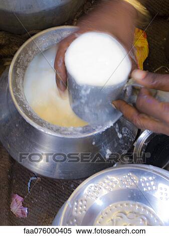 Stock Photography - Person holding cup of lassi, blurred motion. Fotosearch