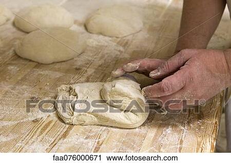 Stock Image - Person kneading bread dough. Fotosearch
