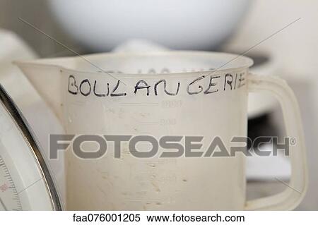 Stock Photography - Plastic measuring cup with "boulangerie" hand written on it. Fotosearch