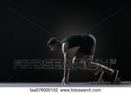 Stock Image - Runner on starting block. Fotosearch