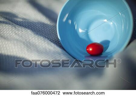 Stock Image - Single grape tomato in bowl. Fotosearch