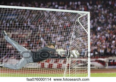 Picture - Soccer goalkeeper diving to block ball. Fotosearch