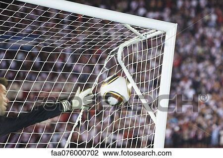 Stock Image - Soccer goalkeeper diving to block ball. Fotosearch