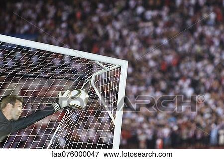 Stock Photo - Soccer goalkeeper diving to block ball. Fotosearch