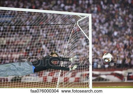 Picture - Soccer goalkeeper diving to guard net. Fotosearch