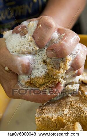 Stock Photo - Squeezing excess milk from bread. Fotosearch