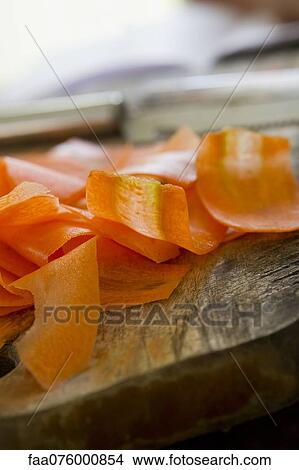 Thin slices of carrot on cutting board View Large Photo Image Picture - Thin slices of carrot on cutting board. Fotosearch