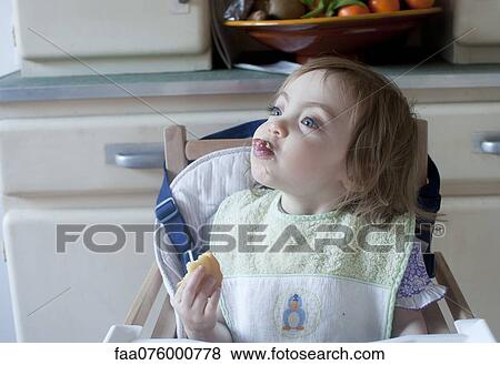 Stock Photo - Toddler girl sticking her tongue out while eating. Fotosearch