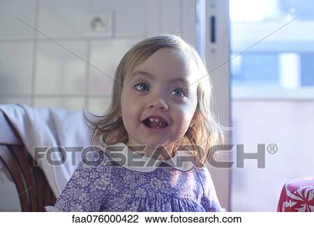 Stock Image - Toddler girl with cheerful expression, portrait. Fotosearch