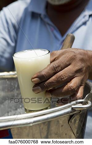 Stock Photo - Vendor selling glass of lassi. Fotosearch