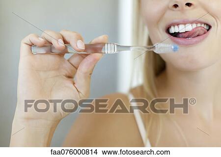 Picture - Woman brushing teeth, cropped. Fotosearch