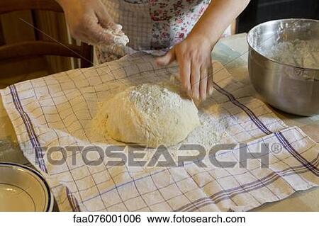 Stock Photograph - Woman flouring fresh dough, cropped. Fotosearch