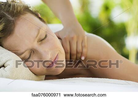 Stock Image - Woman getting a massage at spa. Fotosearch