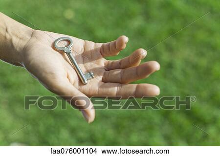 Picture - Woman holding key in palm. Fotosearch