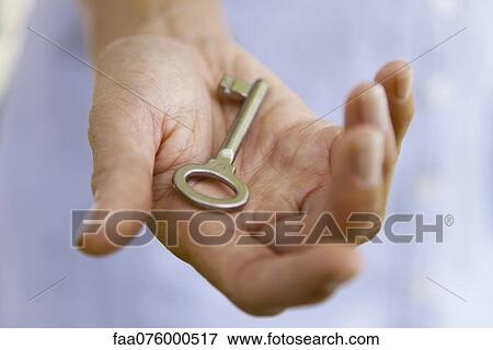Stock Photo - Woman holding key in palm. Fotosearch