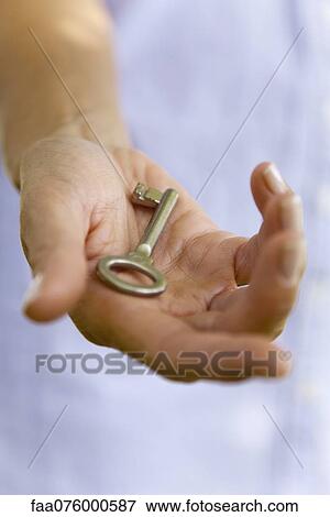 Woman holding key in palm View Large Photo Image Stock Photo - Woman holding key in palm. Fotosearch