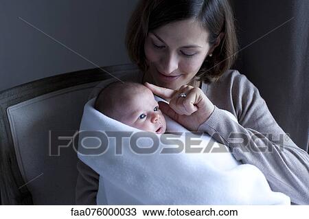Stock Image - Woman holding newborn baby. Fotosearch
