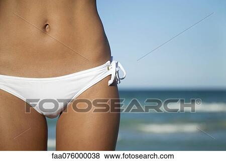 Stock Photo - Woman in bikini bottom, mid section. Fotosearch