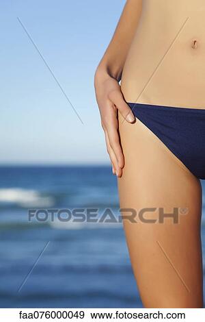 Stock Photo - Woman in bikini bottom, mid section. Fotosearch