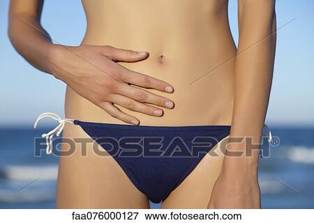 Stock Photo - Woman in bikini bottom, mid section. Fotosearch