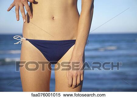 Stock Photography - Woman in bikini bottom, mid section. Fotosearch