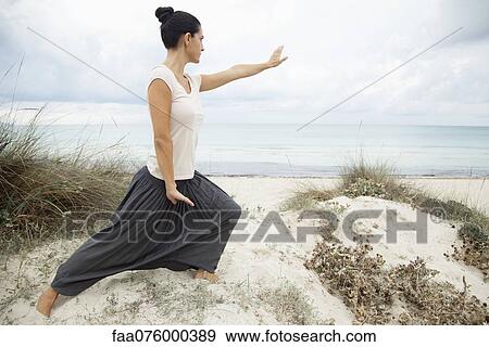 Woman practicing tai chi chuan on beach, side view View Large Photo Image Stock Photo - Woman practicing tai chi chuan on beach, side view. Fotosearch