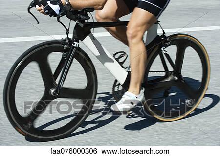 Stock Photograph - Woman riding road bike, low section. Fotosearch
