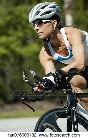 Stock Image - Woman riding road bike, portrait. Fotosearch
