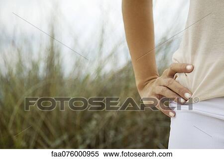 Woman with hand on hip outdoors, cropped View Large Photo Image Stock Photography - Woman with hand on hip outdoors, cropped. Fotosearch